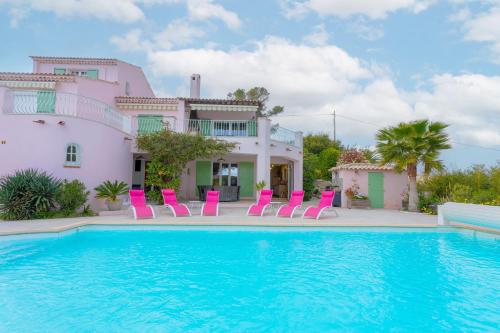 une villa avec une piscine et des chaises roses dans l'établissement Villa le 931, à Fréjus