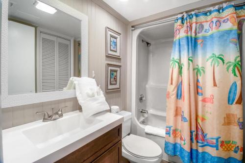 y baño con lavabo, aseo y cortina de ducha. en Seawinds, Oceanfront, 2 BR , Indoor Pool, Hot Tub en Myrtle Beach