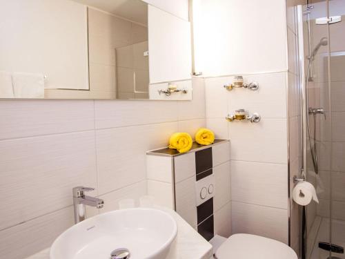 a white bathroom with a toilet and a sink at Inviting apartment in Freyung with sauna indoor pool in Freyung