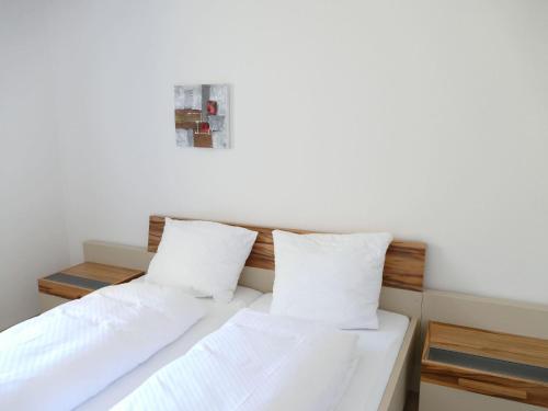 two beds in a room with white sheets and pillows at Inviting apartment in Freyung with sauna indoor pool in Freyung