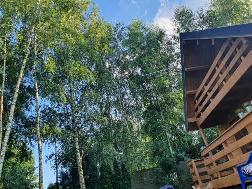 a building with trees in the background at Domek letniskowy in Tręby Stare