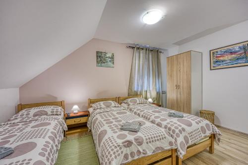 two twin beds in a bedroom with at Rooms Centar in Delnice