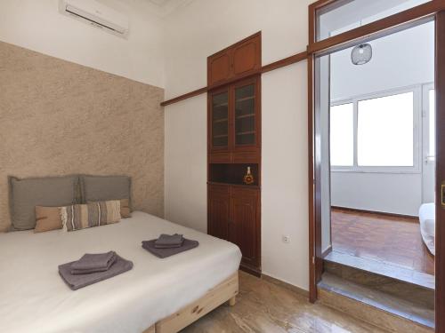 a bedroom with a bed and a large window at Elegant, affordable apartment with a fireplace in Athens