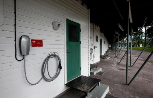 a building with a green door and a phone at Sjögestad Motell in Vikingstad