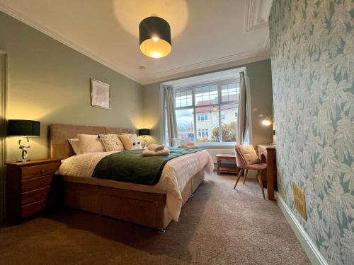 a bedroom with a bed and a window at The Rose- Grd Floor, 2-5 Beds, SmartTV, Uni, Tram, M250 Fibre in Nottingham