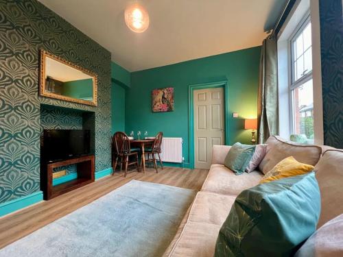 a living room with a couch and a table at The Rose- Grd Floor, 2-5 Beds, SmartTV, Uni, Tram, M250 Fibre in Nottingham