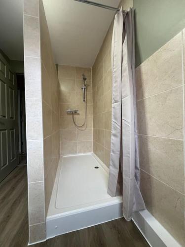 a shower with a shower curtain in a bathroom at The Rose- Grd Floor, 2-5 Beds, SmartTV, Uni, Tram, M250 Fibre in Nottingham