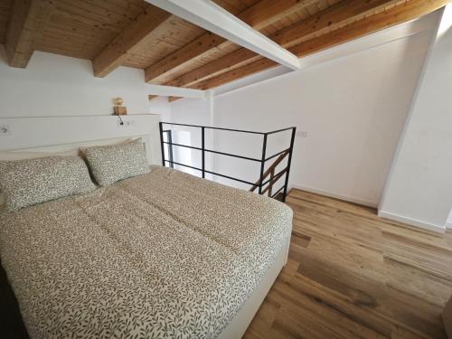 ein Schlafzimmer mit einem Bett in einem Zimmer mit Holzdecken in der Unterkunft Antic Manresa Atico in Manresa