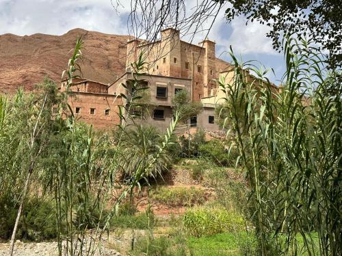 un vieux bâtiment sur le côté d'une montagne dans l'établissement قصبة الحوط, 