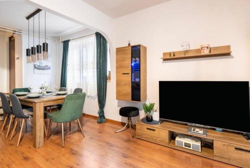 a living room with a television and a table with chairs at Lux apartment Barbara with Jacuzzi in Poreč