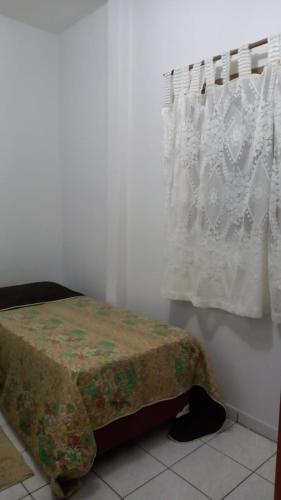 um quarto com uma cama e uma janela com uma cortina em apartamento 02 quartos em São José do Rio Preto