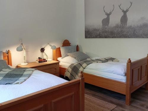 バート・ハルツブルクにあるFerienhaus Am Stadtparkのベッドルーム1室(ベッド2台付)が備わります。壁に鹿の写真が飾られています。