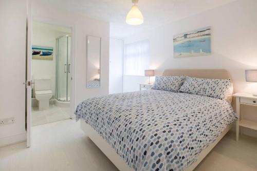 a white bedroom with a bed and a bathroom at The Tardis 5 bedroom, 3 bathroom Oxford City Oasis with Free Parking in Oxford