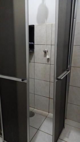 um chuveiro com uma porta aberta na casa de banho em apartamento 02 quartos em São José do Rio Preto