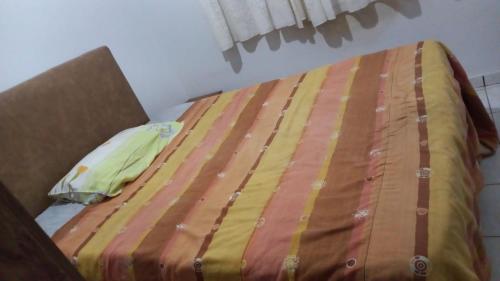 uma cama não feita com um edredão amarelo e castanho em apartamento 02 quartos em São José do Rio Preto