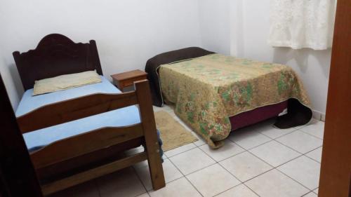 um pequeno quarto com duas camas e uma mesa em apartamento 02 quartos em São José do Rio Preto