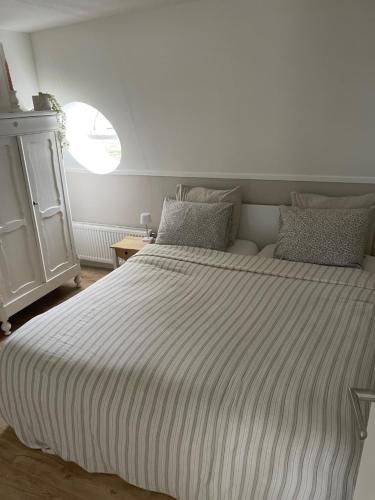 a bedroom with a large bed with a striped blanket at Veldhorst Apartments in Leiden