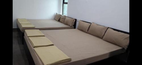 un grupo de camas en una habitación en Srirangam Homestay, en Srīrangam
