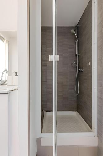 une douche avec une porte vitrée dans une salle de bain dans l'établissement Le Jungle Trefilerie Spacieux - équipé - Wifi - TV - Calme, à Saint-Étienne