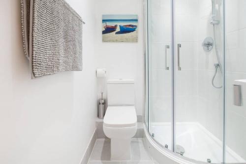 a white bathroom with a toilet and a shower at The Tardis 5 bedroom, 3 bathroom Oxford City Oasis with Free Parking in Oxford