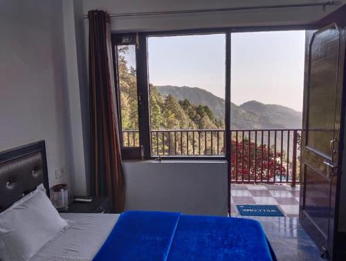 a bedroom with a bed and a view of a balcony at DREAM HILLS B&B in Dalhousie