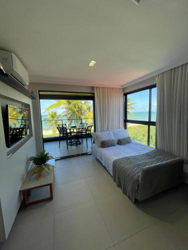a bedroom with a bed and a view of the ocean at Altamare - Pé na areia in Tambaú