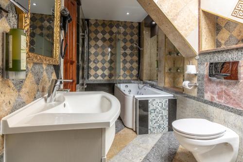 a bathroom with a sink and a toilet and a tub at Best Western Hotel Strasser in Graz