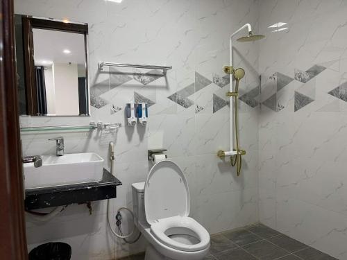 ein Badezimmer mit einem WC, einem Waschbecken und einem Spiegel in der Unterkunft Hotel Việt Hàn in Việt Yên