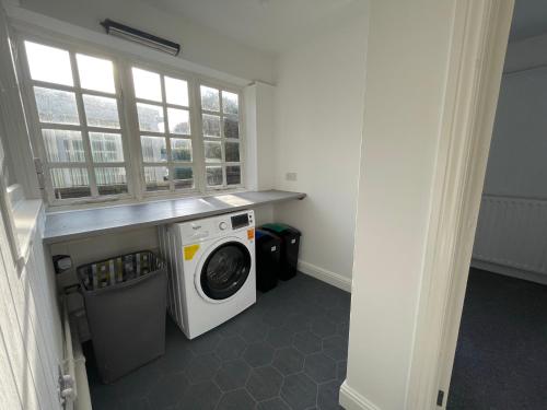 a laundry room with a washing machine and a window at Meadow Lark in Old Somerby