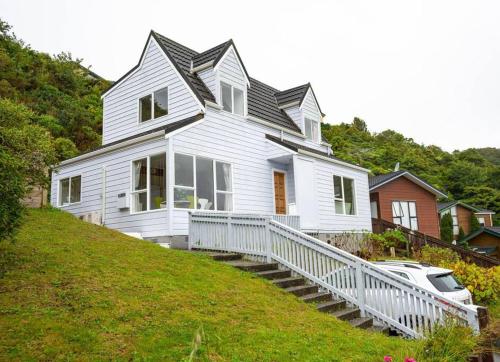 a white house on the side of a hill at Big sale in winter three bedrooms two bathrooms in karori in Wellington