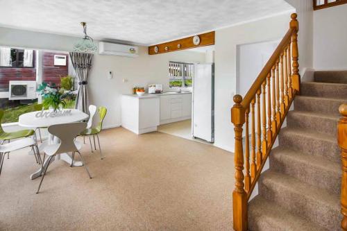 a kitchen and dining room with a table and a staircase at Big sale in winter three bedrooms two bathrooms in karori in Wellington