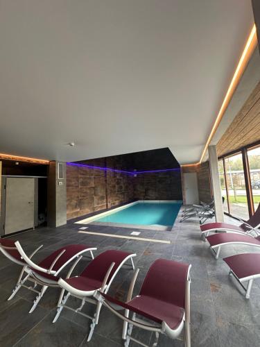 Les Hôpitaux-Neufs的住宿－Résidence Le Sommet，一个带椅子的游泳池和一个游泳池