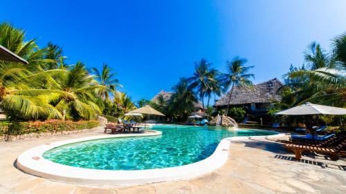 a swimming pool with chairs and umbrellas in a resort at Tembo Court Apartments in Malindi