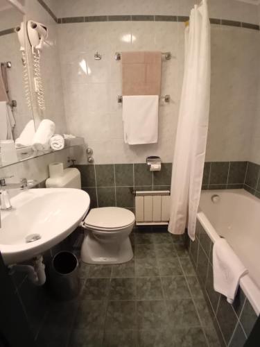 a bathroom with a toilet and a sink and a tub at Senator Ház in Eger