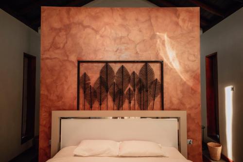 a bedroom with a bed in front of a wall at The Villa Lakeshore in Anuradhapura