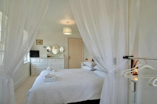 a bedroom with a white bed with towels on it at Finest Retreats - Nicely Tucked Away Cottage in Torpoint