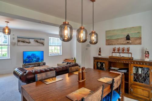 a living room with a table and a couch at Finest Retreats - Nicely Tucked Away Cottage in Torpoint