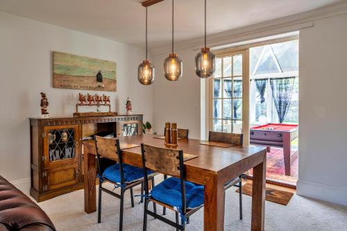 a dining room with a wooden table and chairs at Finest Retreats - Nicely Tucked Away Cottage in Torpoint