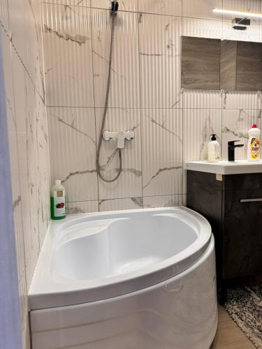 uma banheira branca na casa de banho com um chuveiro em Апартаменты с трансфером em Chisinau