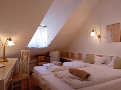 a bedroom with two beds in a attic at Senator Ház in Eger