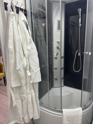 a rack of white clothes hanging in a shower at Pensiunea Cascada Putnei in Lepşa