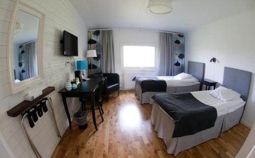 a hotel room with two beds and a desk at Sjögestad Motell in Vikingstad