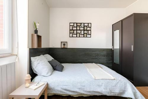 une chambre avec un grand lit avec une tête de lit noire dans l'établissement Le Jungle Trefilerie Spacieux - équipé - Wifi - TV - Calme, à Saint-Étienne