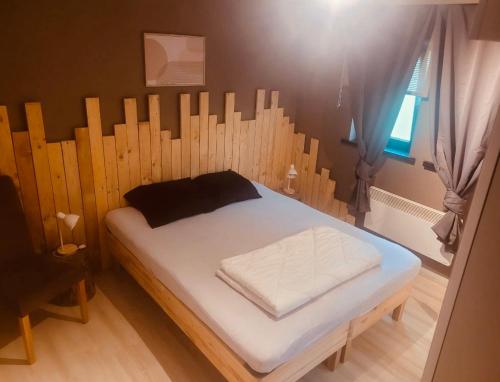 een bed in een kamer met een houten hek bij Noax gite Durbuy in Durbuy