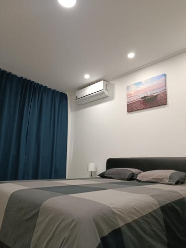 a bedroom with a large bed with a blue curtain at Plaza Caparica Hostel in Costa da Caparica