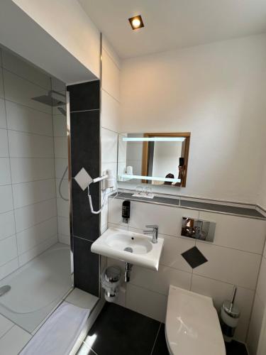 a bathroom with a sink and a toilet and a mirror at Hotel Stadt Emmerich in Emmerich