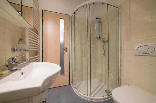ein Bad mit einer Dusche, einem Waschbecken und einem WC in der Unterkunft HOTEL U STAVAŘE - Hotelová DEPANDANCE in Vsetín
