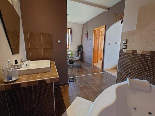 a bathroom with a white tub and a sink at Wellness Lakás in Nyíregyháza