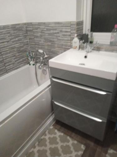 a bathroom with a sink and a bath tub next to a sink at Cosy & bright room in Loughborough