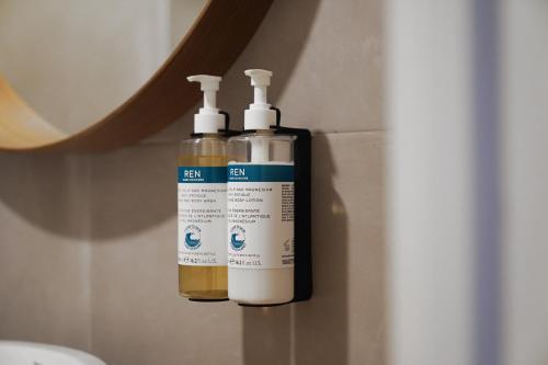 two bottles of disinfectants are hanging on a wall at Numa Madrid Sol in Madrid